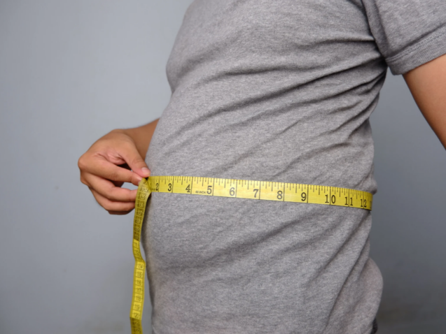 adult-measuring-waist-with-yellow-tape-measure-2026-03-18-12-19-15-utc