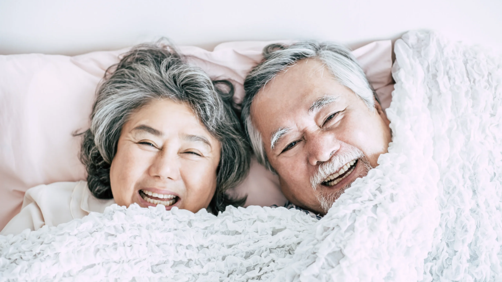 happy-senior-couple-laughing-in-bed-together-2026-01-07-00-55-39-utc
