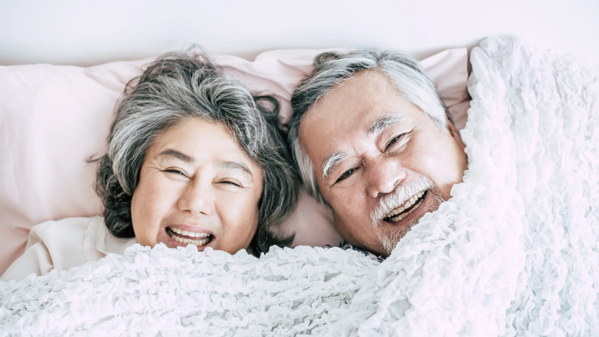 happy-senior-couple-laughing-in-bed-together-2026-01-07-00-55-39-utc